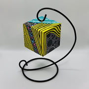 3-D CUBE ART #16 by Mary-Jo Lough, hand-painted 2.25” cube made from solid wood, featuring vibrant abstract art and layered details on a hanging stand.