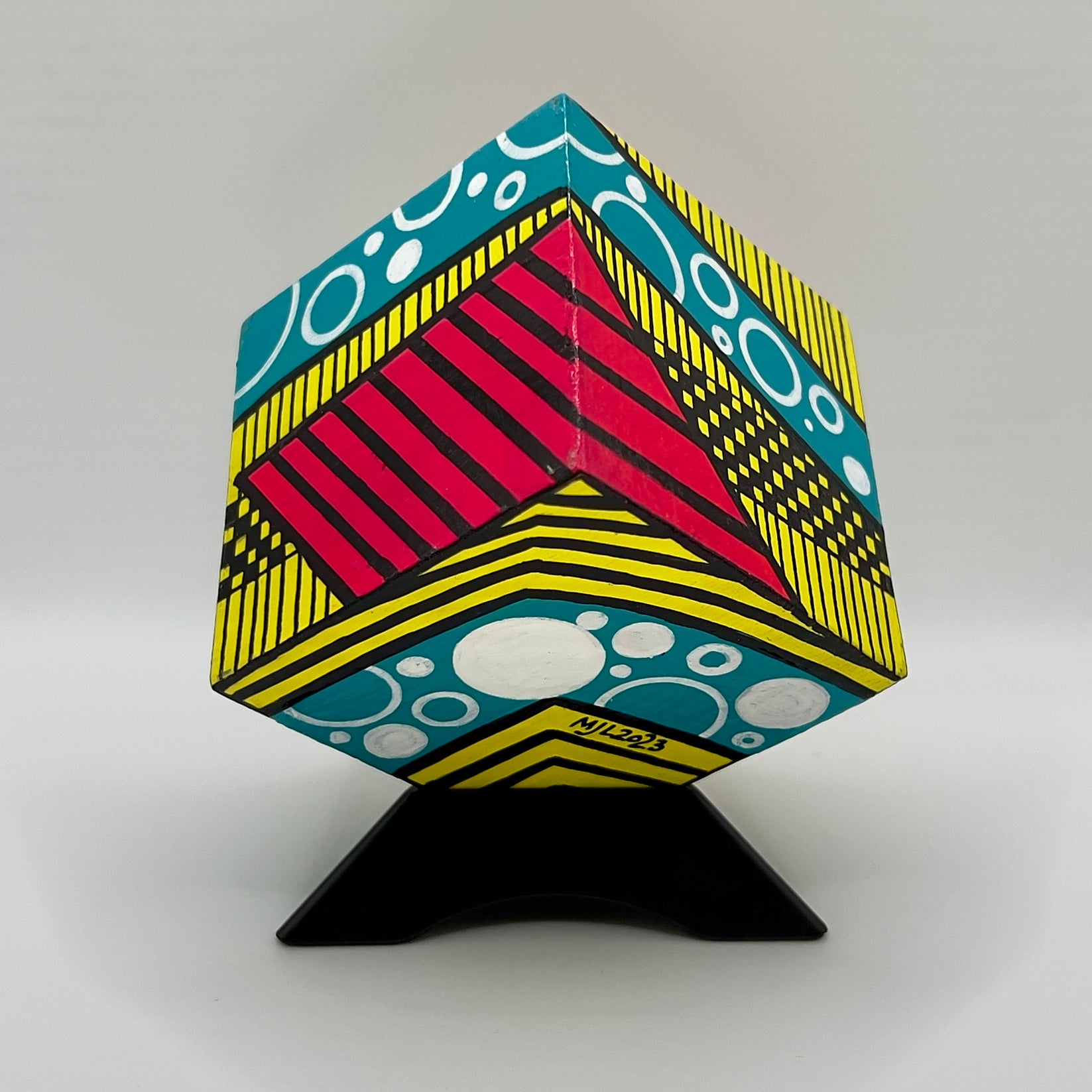 3-D CUBE ART #18 by Mary-Jo Lough, hand-painted 2.25” cube made from solid wood, featuring vibrant abstract art and layered details on a triangle stand.