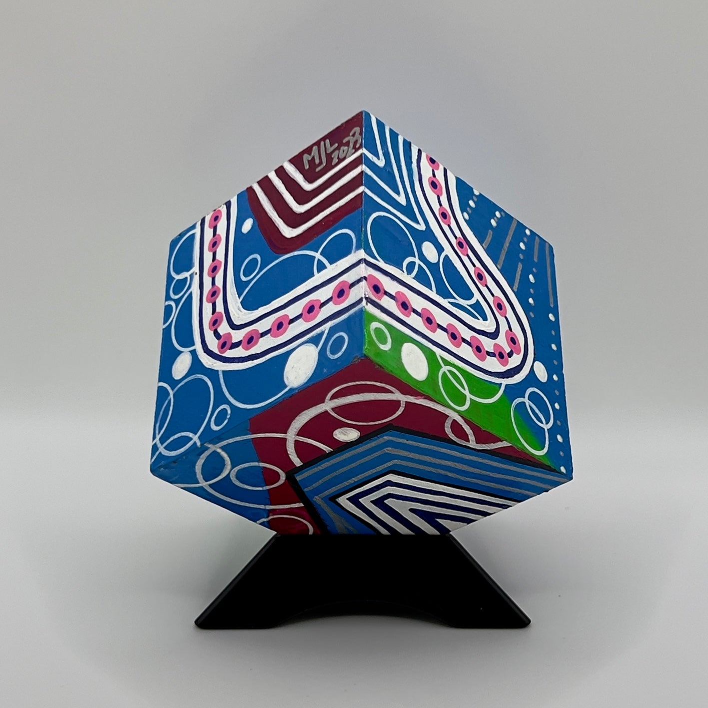 3-D CUBE ART #24 by Mary-Jo Lough, hand-painted 2.25” cube made from solid wood, featuring vibrant abstract art and layered details on a triangle stand.