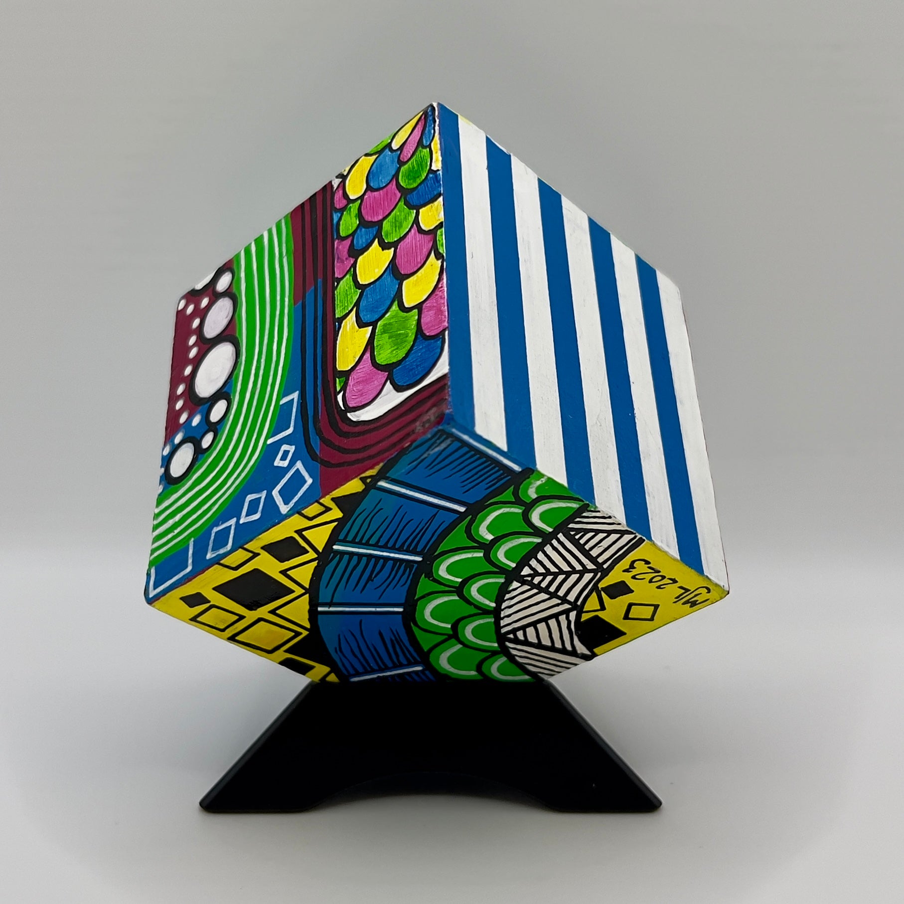 3-D CUBE ART #28 by Mary-Jo Lough, hand-painted 2.25” cube made from solid wood, featuring vibrant abstract art and layered details on a triangle stand.